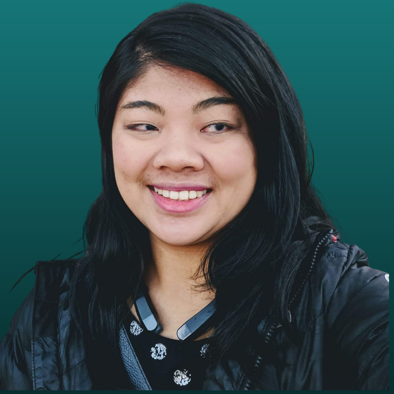 A headshot of Carrie Morales, a blind Asian woman with black hair wearing a black jacket with headphones around her neck.