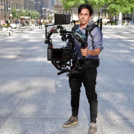 A photo of Nick Bruckman holding a large camera.