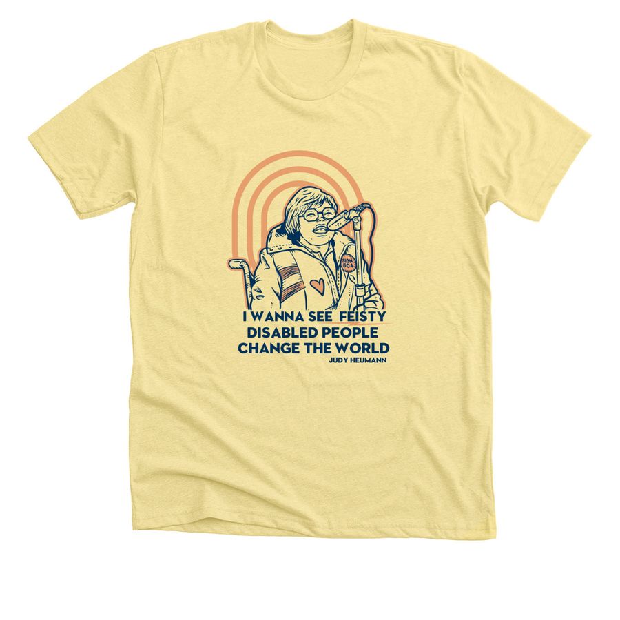 A yellow t-shirt with a navy blue and orange drawing of Judy Heumann and the quote “I wanna see feisty disabled people change the world. Judy Heumann” in navy blue text.