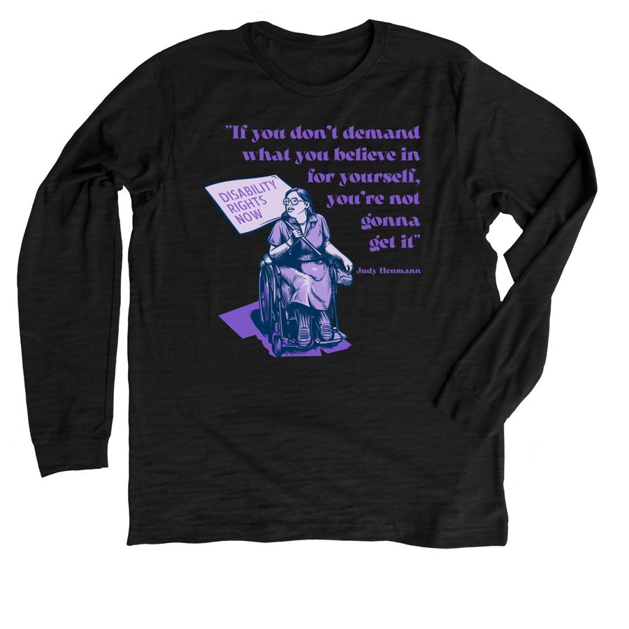 A black long sleeve t-shirt with a purple design on it. The design is an image of Judy Heumann, a white woman who uses a wheelchair, wearing a dress and glasses. She is holding a sign that reads "Disability Rights Now." Around this image is a quote that reads "If you don't demand what you believe in for yourself, you're not gonna get it" and it's attributed to Judy Heumann.