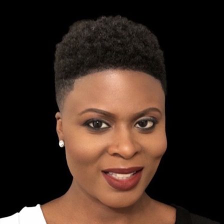 A headshot of Chimére Smith, a black woman with short brown hair wearing red lipstick and silver earrings