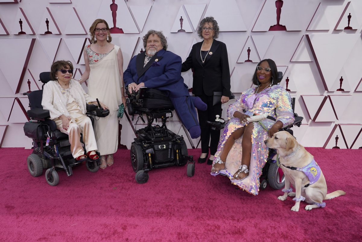 Judith Heumann, from left, Nicole Newnham, James LeBrecht, Sara Bolder, Andraea LaVant and service dog Gofi LaVant arrive at the Oscars on Sunday, April 25, 2021, at Union Station in Los Angeles. (AP Photo/Chris Pizzello, Pool)