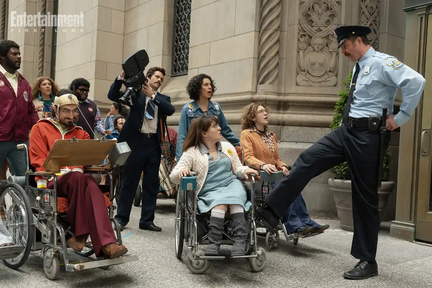 Ruth Madeley as Judy Heumann being stopped by a police officer on the street